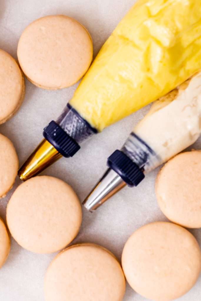 Créme brûlée macarons inspired by trendy crème brûlée donuts, complete with a creamy vanilla custard center and a crisp caramelized dipped shell. A dairy free and gluten free macaron recipe. Enjoy with tea, coffee, or champagne.
