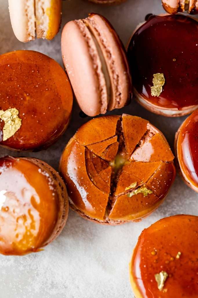 Créme brûlée macarons inspired by trendy crème brûlée donuts, complete with a creamy vanilla custard center and a crisp caramelized dipped shell. A dairy free and gluten free macaron recipe. Enjoy with tea, coffee, or champagne.