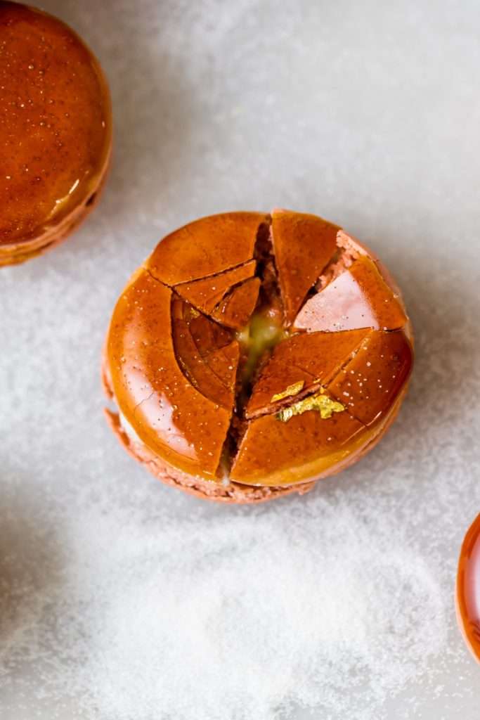 Créme brûlée macarons inspired by trendy crème brûlée donuts, complete with a creamy vanilla custard center and a crisp caramelized dipped shell. A dairy free and gluten free macaron recipe. Enjoy with tea, coffee, or champagne.