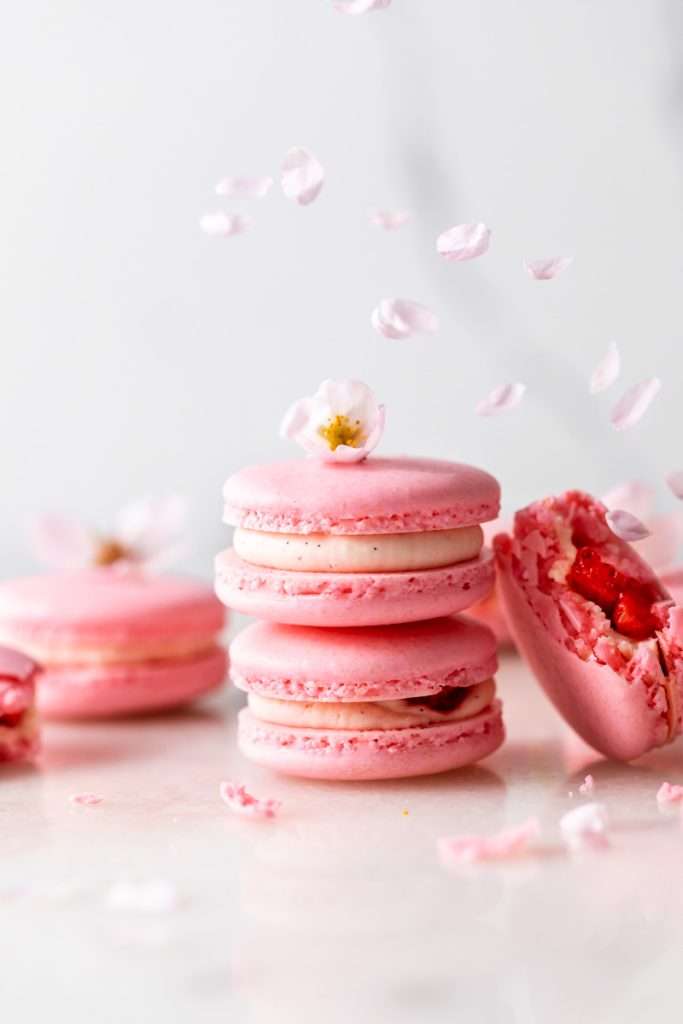 Spring macaron recipe filled with Sakura cherry blossom frosting and a fresh strawberry center. Dairy Free, Gluten Free and the perfect macaron and treat for spring.