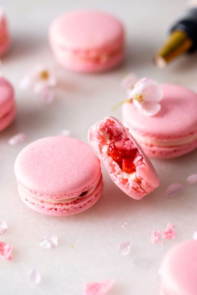 Spring macaron recipe filled with Sakura cherry blossom frosting and a fresh strawberry center. Dairy Free, Gluten Free and the perfect macaron and treat for spring.