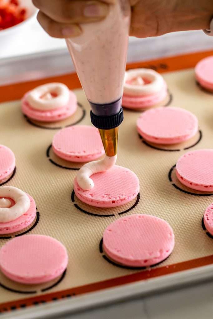 Spring macaron recipe filled with Sakura cherry blossom frosting and a fresh strawberry center. Dairy Free, Gluten Free and the perfect macaron and treat for spring.