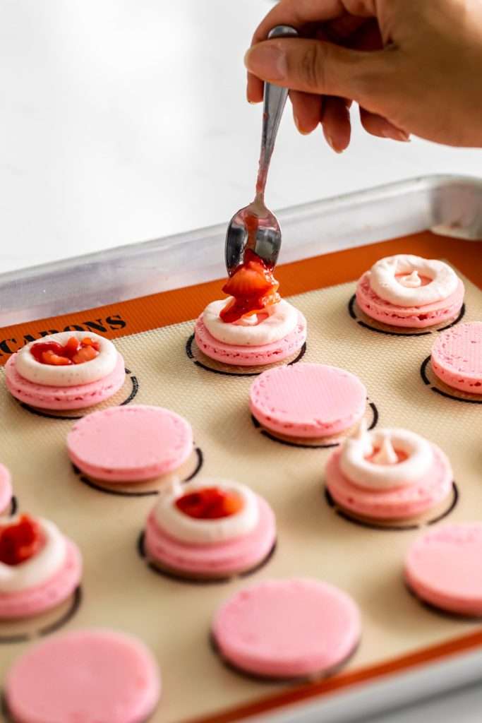 Spring macaron recipe filled with Sakura cherry blossom frosting and a fresh strawberry center. Dairy Free, Gluten Free and the perfect macaron and treat for spring.