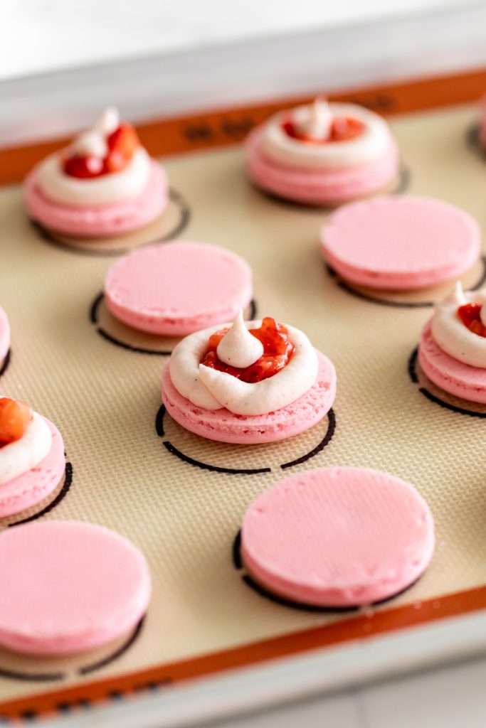 Spring macaron recipe filled with Sakura cherry blossom frosting and a fresh strawberry center. Dairy Free, Gluten Free and the perfect macaron and treat for spring.