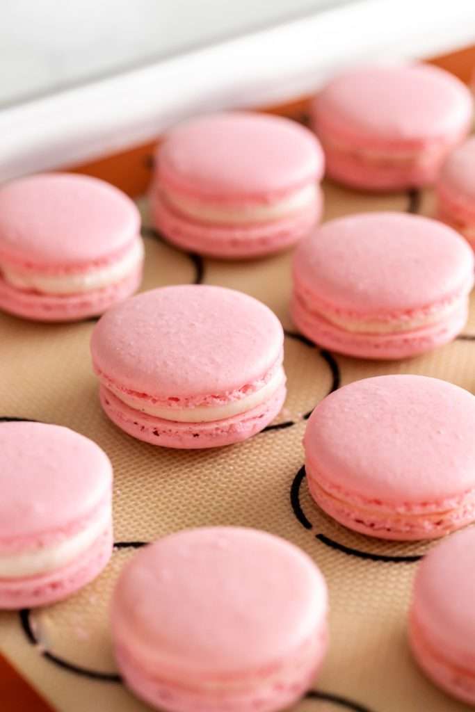 Spring macaron recipe filled with Sakura cherry blossom frosting and a fresh strawberry center. Dairy Free, Gluten Free and the perfect macaron and treat for spring.
