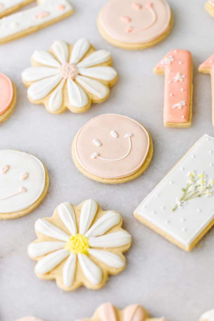 Kids retro themed sugar cookies decorated with royal icing. Smiley face and daisy birthday cookies.