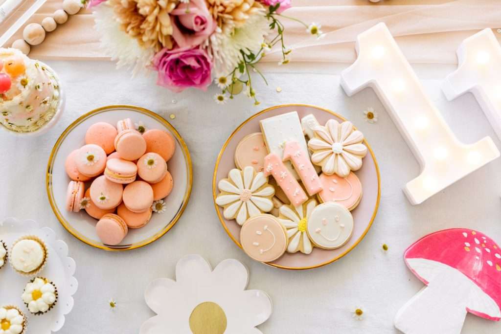 Kids retro themed birthday party desserts. Sugar cookies, macarons, cupcakes