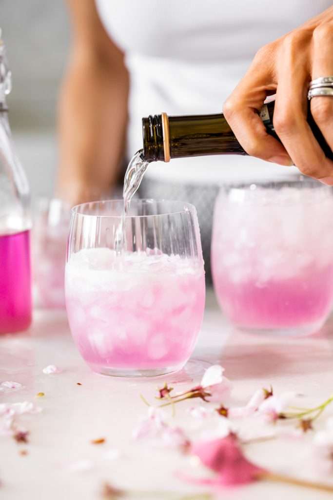 Sakura Cherry Blossom spritz cocktail! It's delicate and refreshing and the prettiest shade of pink, perfect for spring and summer parties and upcoming Mother's Day. Shake and pour over ice! Cheers