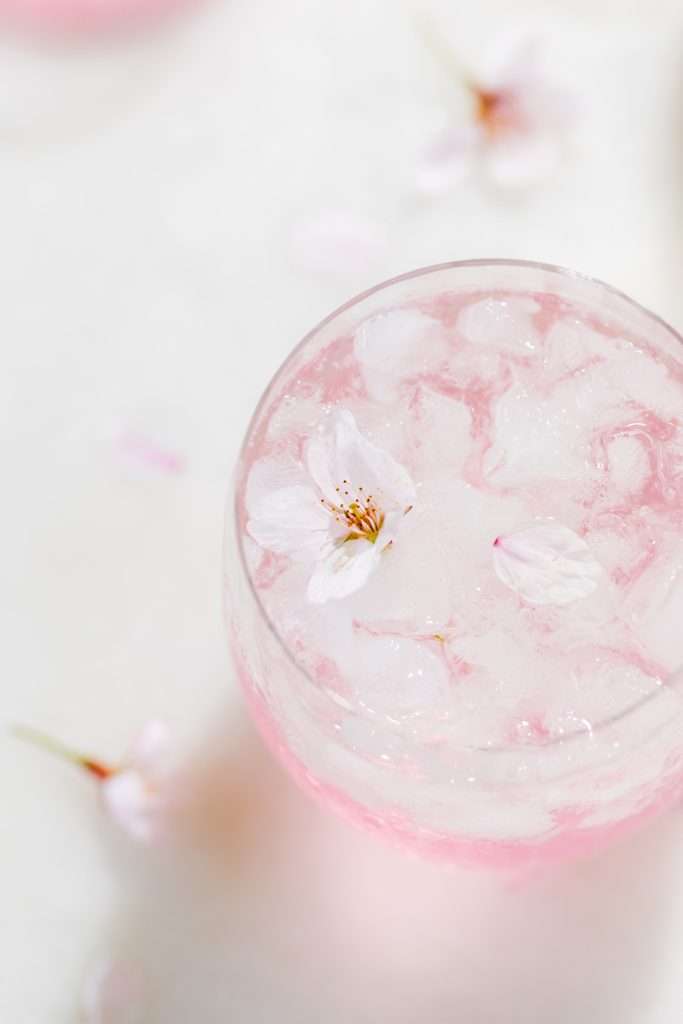 Sakura Cherry Blossom spritz cocktail! It's delicate and refreshing and the prettiest shade of pink, perfect for spring and summer parties and upcoming Mother's Day. Shake and pour over ice! Cheers