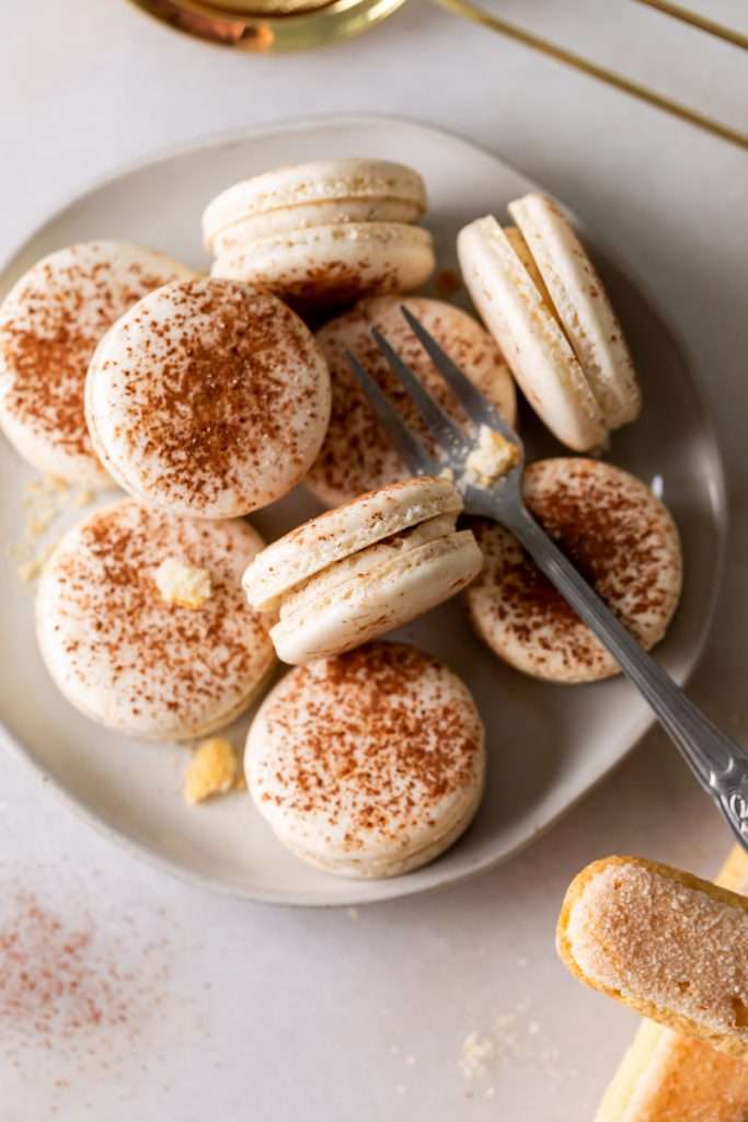 Tiramisu flavored macarons, with a tangy mascarpone filling and coffee soaked ladyfinger center. Decorated with a light dusting of cocoa powder to mimic the look of tiramisu.&nbsp;