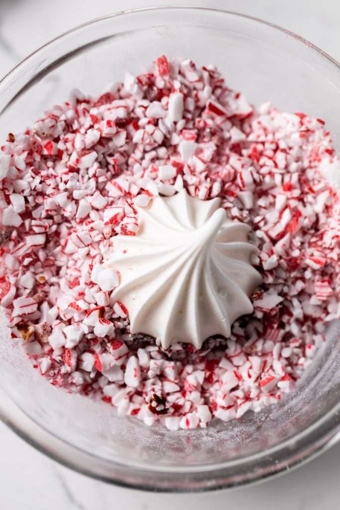 Chocolate dipped peppermint meringue cookies topped with crushed candy canes for Christmas.