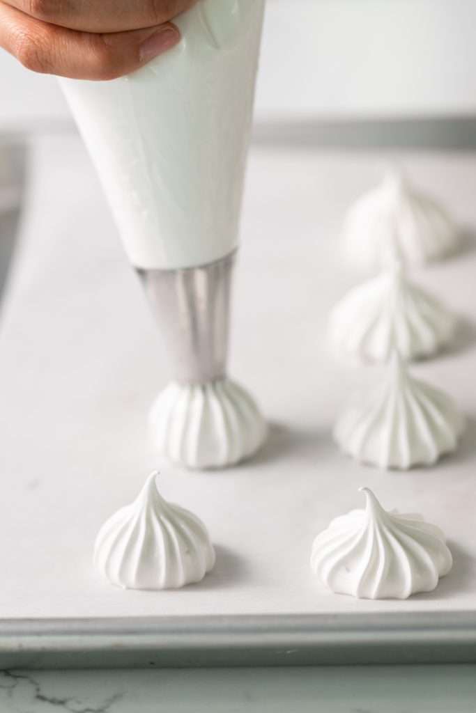 Chocolate dipped peppermint meringue cookies topped with crushed candy canes for Christmas.