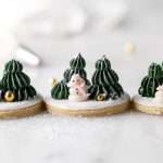 Cute winter themed sugar cookies, simply flooded with a royal icing base, then decorated with easy three dimension trees and snowmen, using star and round piping tips. This simple Christmas cookie design requires little experience with royal icing to complete from start to finish!