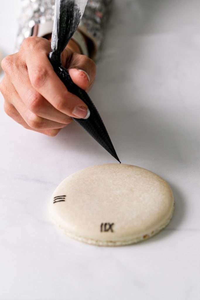 Chocolate hazelnut macaron cake decorated with a Roman numeral clock design for New Years Eve. Dairy Free & Gluten Free. Recipe & Tutorial.