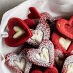Easy red velvet Linzer cookies, with a hint of cocoa, and tangy cream cheese frosting. These cookies ca be cut into any shape and are the perfect treat for any occasion from Valentine's Day to Christmas.