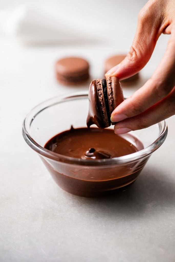 Hostess cupcake inspired macarons, with rich dark chocolate frosting and fluffy marshmallow filling. The shells are dipped in dark chocolate and decorated with icing loops to complete the look and taste! Check out the recipe, video and step by step instructions. Dairy free and gluten free option.