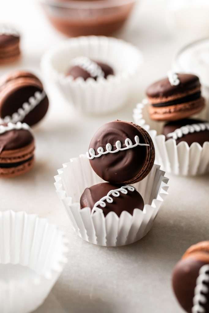 Hostess cupcake inspired macarons, with rich dark chocolate frosting and fluffy marshmallow filling. The shells are dipped in dark chocolate and decorated with icing loops to complete the look and taste! Check out the recipe, video and step by step instructions. Dairy free and gluten free option.