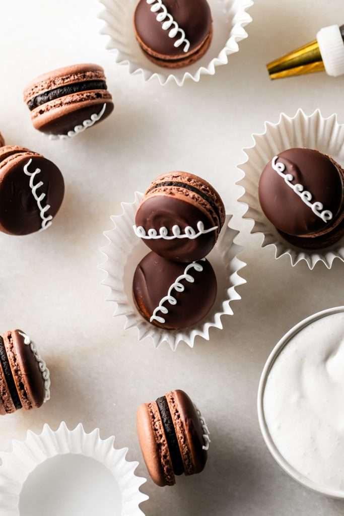 Hostess cupcake inspired macarons, with rich dark chocolate frosting and fluffy marshmallow filling. The shells are dipped in dark chocolate and decorated with icing loops to complete the look and taste! Check out the recipe, video and step by step instructions. Dairy free and gluten free option.