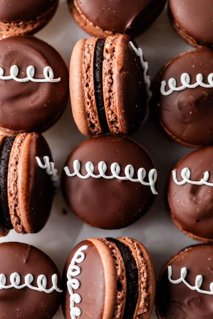 Hostess cupcake inspired macarons, with rich dark chocolate frosting and fluffy marshmallow filling. The shells are dipped in dark chocolate and decorated with icing loops to complete the look and taste! Check out the recipe, video and step by step instructions. Dairy free and gluten free option.