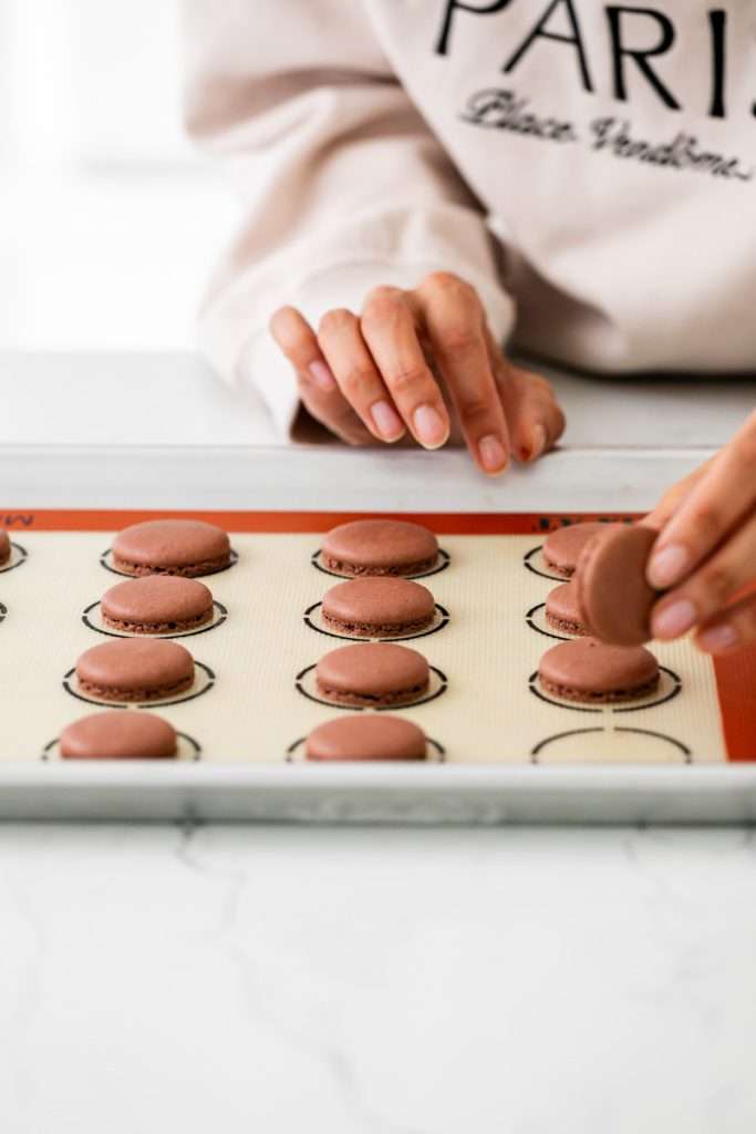 Hostess cupcake inspired macarons, with rich dark chocolate frosting and fluffy marshmallow filling. The shells are dipped in dark chocolate and decorated with icing loops to complete the look and taste! Check out the recipe, video and step by step instructions. Dairy free and gluten free option.
