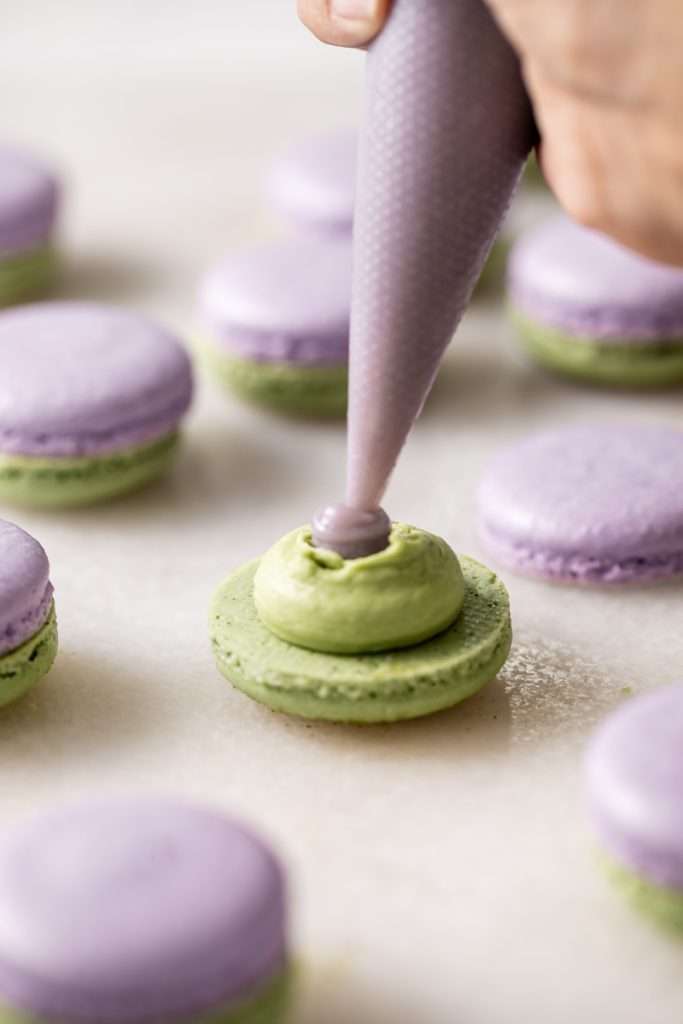 Indulge in a delicious lavender matcha macaron, inspired by the new Starbucks Lavender Matcha latte. From the earthy matcha frosting to the the delicate lavender chocolate ganache sandwiched between two tone almond macaron shells, they are not only delicious but perfect for your upcoming spring gatherings!