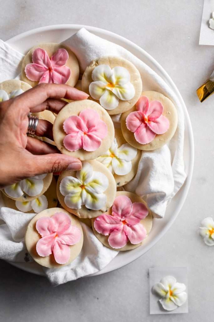 Recipe for tropical sugar cookies, infused with fresh passion fruit and decorated with plumeria royal icing transfers. Step by step instructions and video included.
