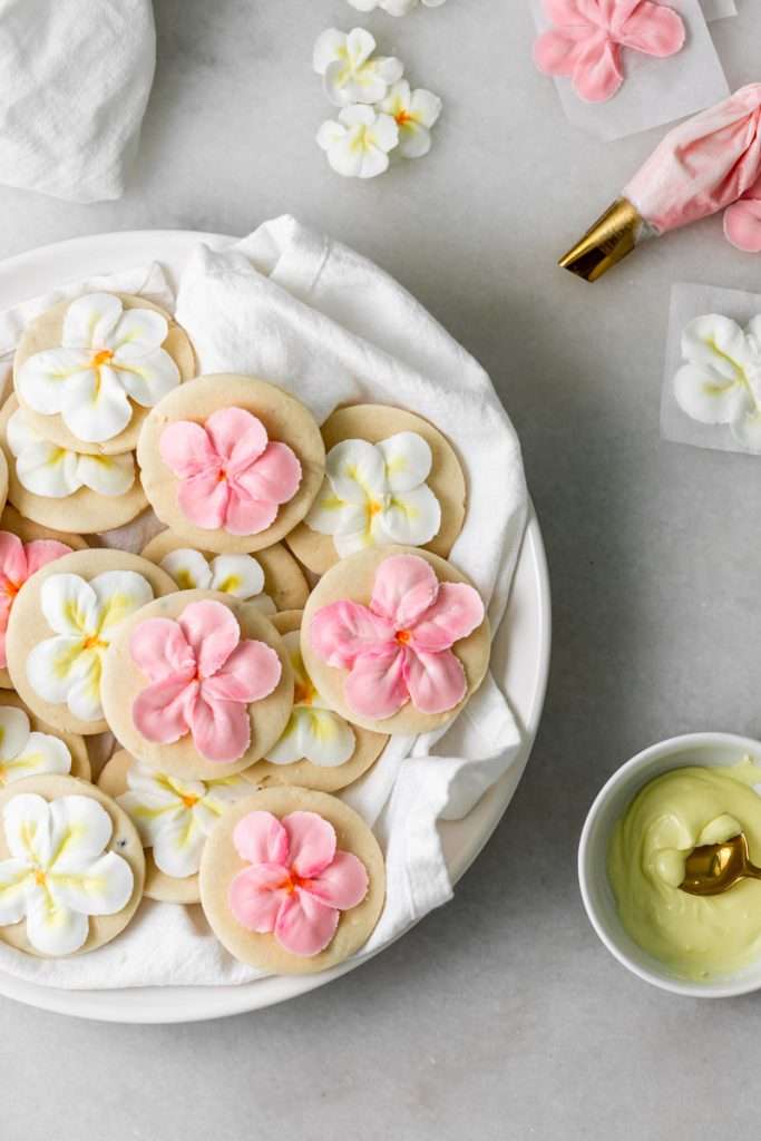 Recipe for tropical sugar cookies, infused with fresh passion fruit and decorated with plumeria royal icing transfers. Step by step instructions and video included.
