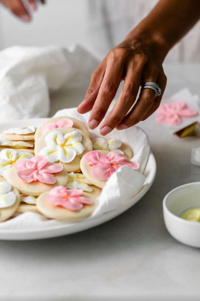 Recipe for tropical sugar cookies, infused with fresh passion fruit and decorated with plumeria royal icing transfers. Step by step instructions and video included.