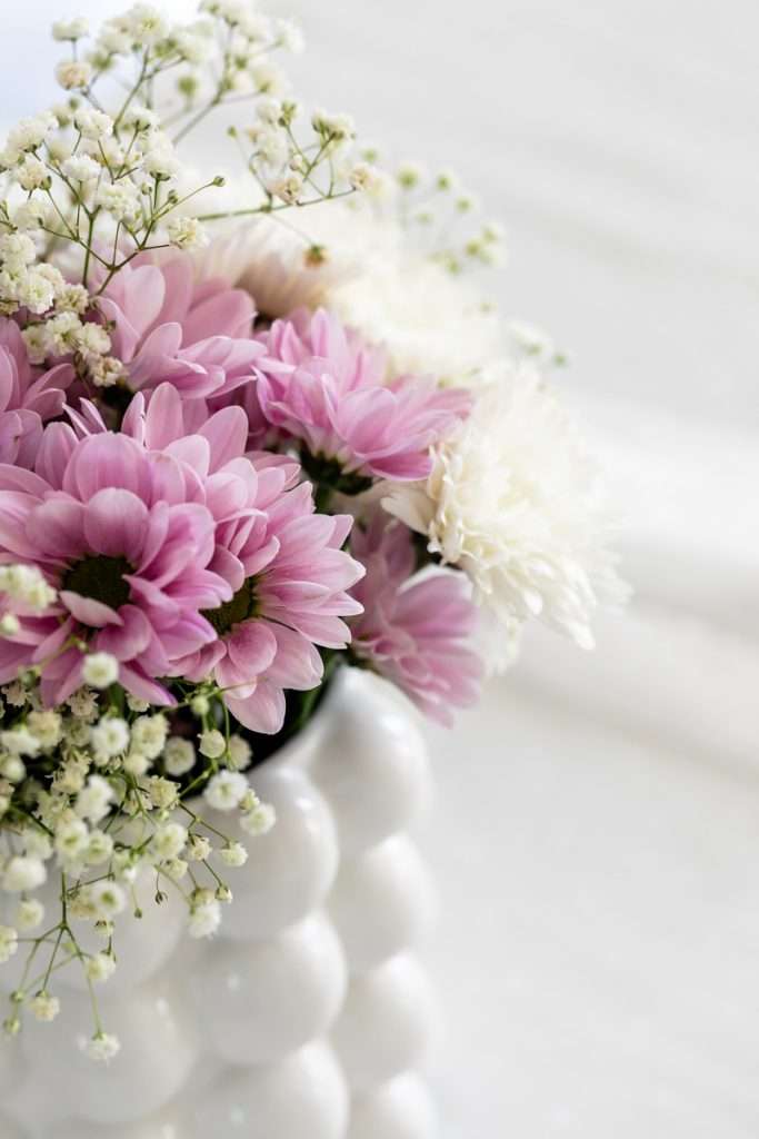 Purple summer floral centerpiece for flower themed birthday party. Mums, and babies breath.