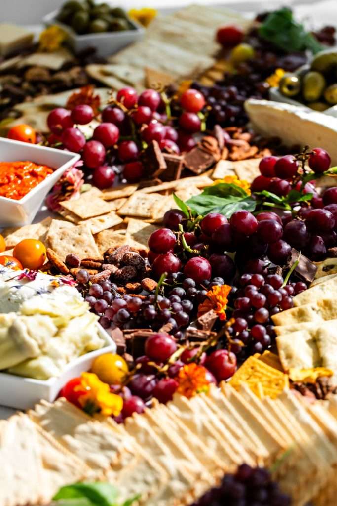 Summer charcuterie board with fresh berries, fruit, cheese, bread, crackers, nuts and more.