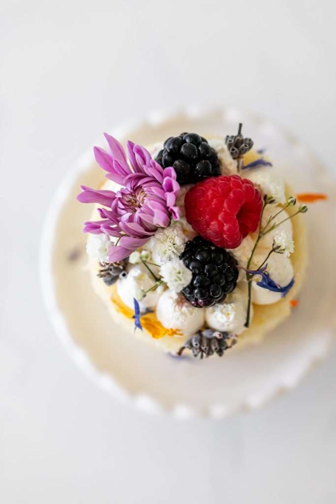 Mini birthday cake topped with berries and blooms for summer birthday