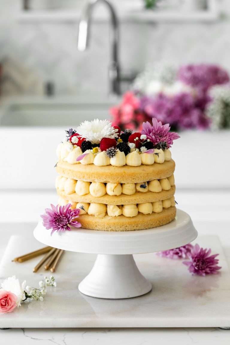 Summer birthday cake with fresh flowers, vanilla frosting and fresh berries. Teen birthday party desserts. Teen birthday party inspiration.