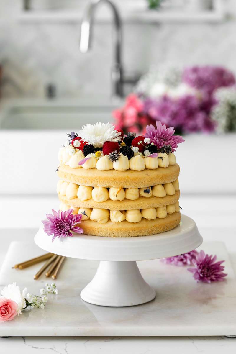 Summer birthday cake with fresh flowers, vanilla frosting and fresh berries. Teen birthday party desserts. Teen birthday party inspiration.