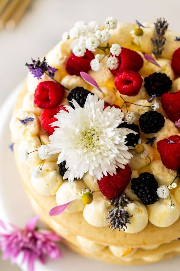 Summer birthday cake with fresh flowers, vanilla frosting and fresh berries. Teen birthday party desserts. Teen birthday party inspiration.