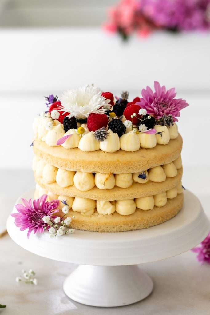 Summer birthday cake with fresh flowers, vanilla frosting and fresh berries. Teen birthday party desserts. Teen birthday party inspiration.