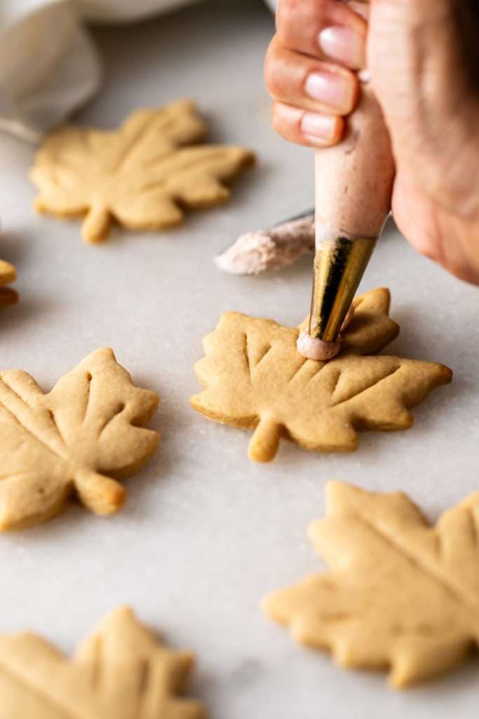 Easy and delicious maple leaf cookies, inspired by Canadian maple cookies filled with maple buttercream and simply decorated with edible gold. A wonderful treat for the fall season and for upcoming fall gatherings. Dairy free option included.