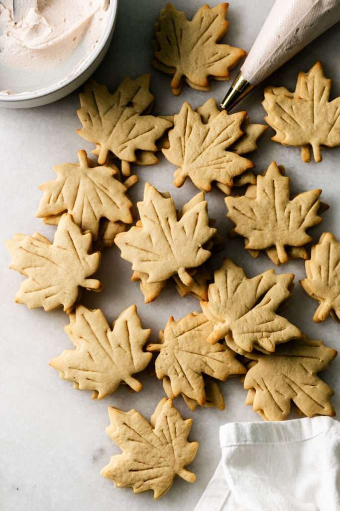 Easy and delicious maple leaf cookies, inspired by Canadian maple cookies filled with maple buttercream and simply decorated with edible gold. A wonderful treat for the fall season and for upcoming fall gatherings. Dairy free option included.