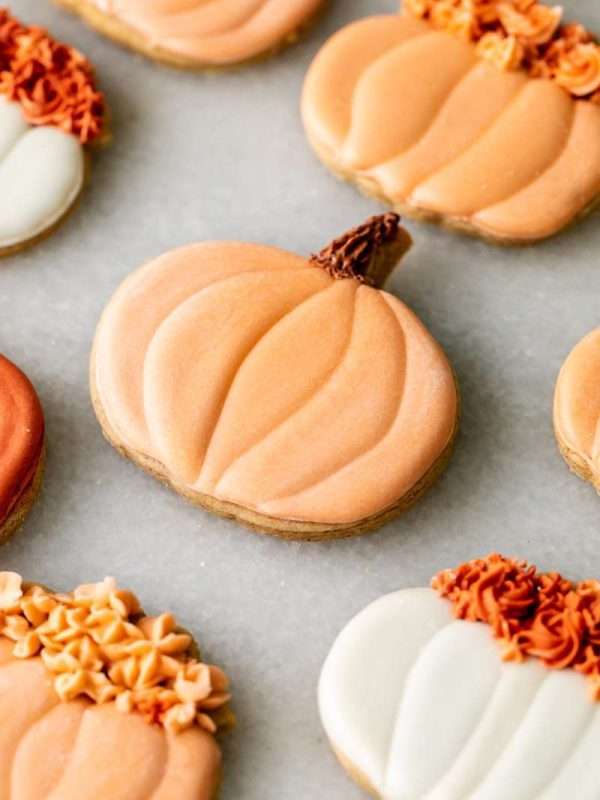 New downloadable recipe for Pumpkin Spice flavored sugar cookies, baked with pumpkin purée and pumpkin spice blend and decorated with vanilla royal icing. They are cozy, flavorful and the perfect seasonal roll out cookie to try this fall season. Dairy free option included!