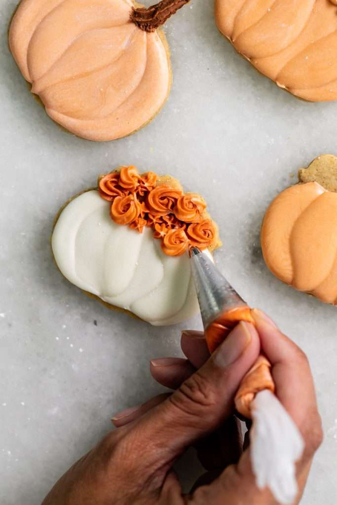 New downloadable recipe for Pumpkin Spice flavored sugar cookies, baked with pumpkin purée and pumpkin spice blend and decorated with vanilla royal icing. They are cozy, flavorful and the perfect seasonal roll out cookie to try this fall season. Dairy free option included!