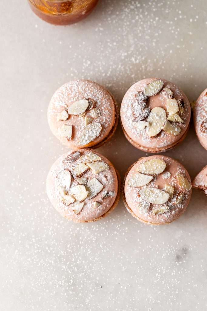 Almond Apricot Macarons filled with almond flavored ganache and apricot preserves. An effortless and delicious macaron flavor for the spring and summer season. Recipe is dairy free and gluten free.