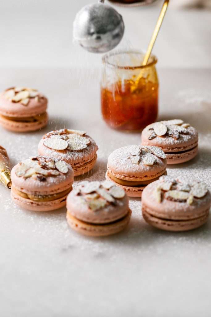 Almond Apricot Macarons filled with almond flavored ganache and apricot preserves. An effortless and delicious macaron flavor for the spring and summer season. Recipe is dairy free and gluten free.