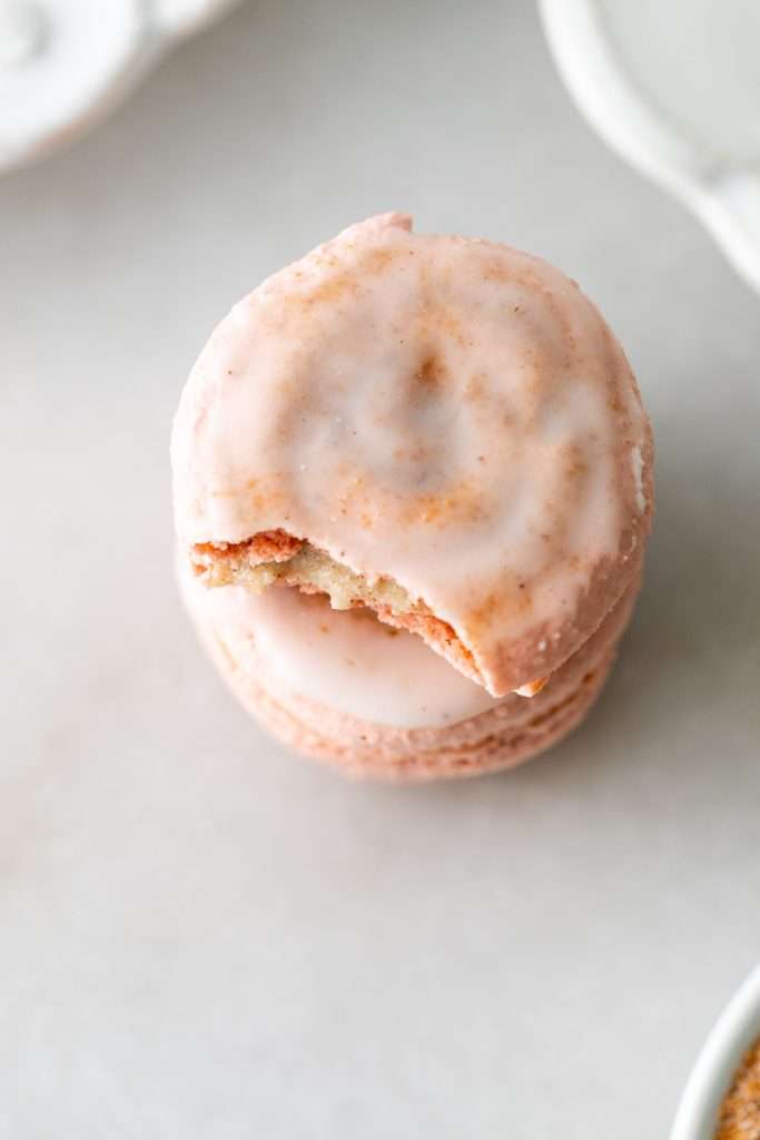 Cinnamon roll flavored macarons for breakfast and brunch. The swirled shells are filled with cinnamon roll white chocolate ganache and topped with icing for the ultimate cinnamon roll flavor. A gluten free recipe.
