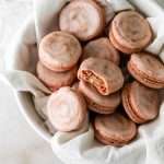 Cinnamon roll flavored macarons for breakfast and brunch. The swirled shells are filled with cinnamon roll white chocolate ganache and topped with icing for the ultimate cinnamon roll flavor. A gluten free recipe.