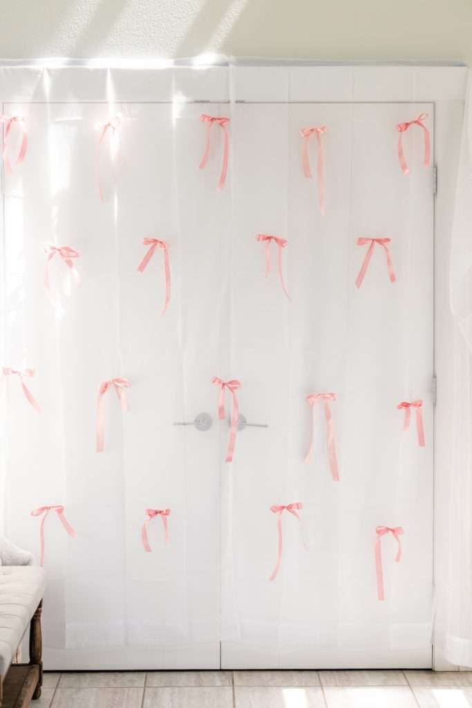 DIY pink satin bow backdrop for coquette bow themed birthday party
