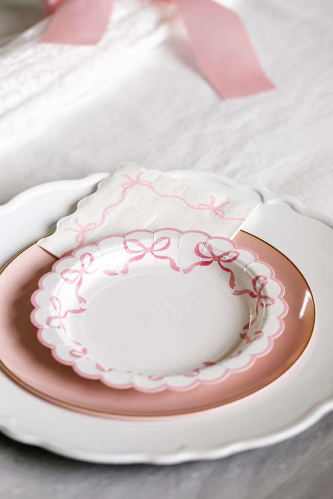 Pink scalloped bow paper plates for coquette bow themed teen birthday party