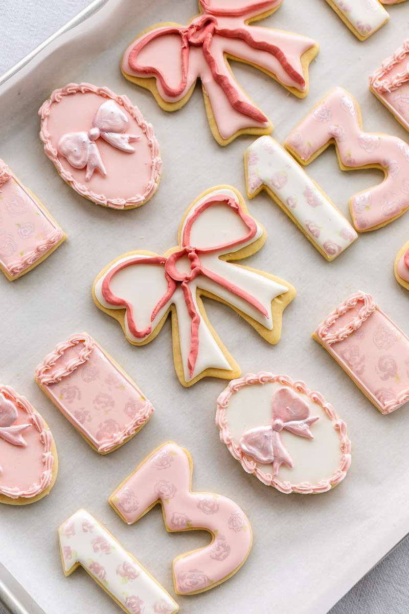 Pink coquette and bow themed custom sugar cookies with royal icing for teen birthday parties. Dessert ideas.