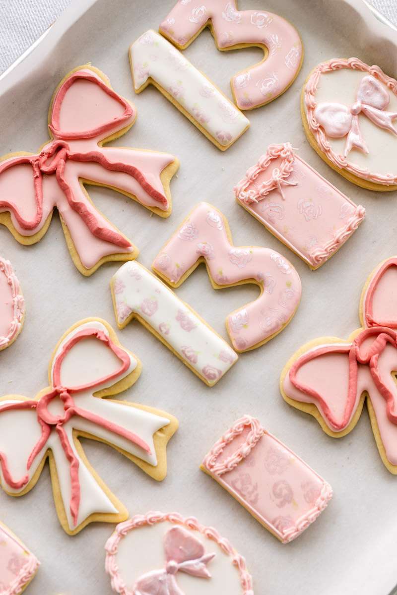 Pink coquette and bow themed custom sugar cookies with royal icing for teen birthday parties. Dessert ideas.