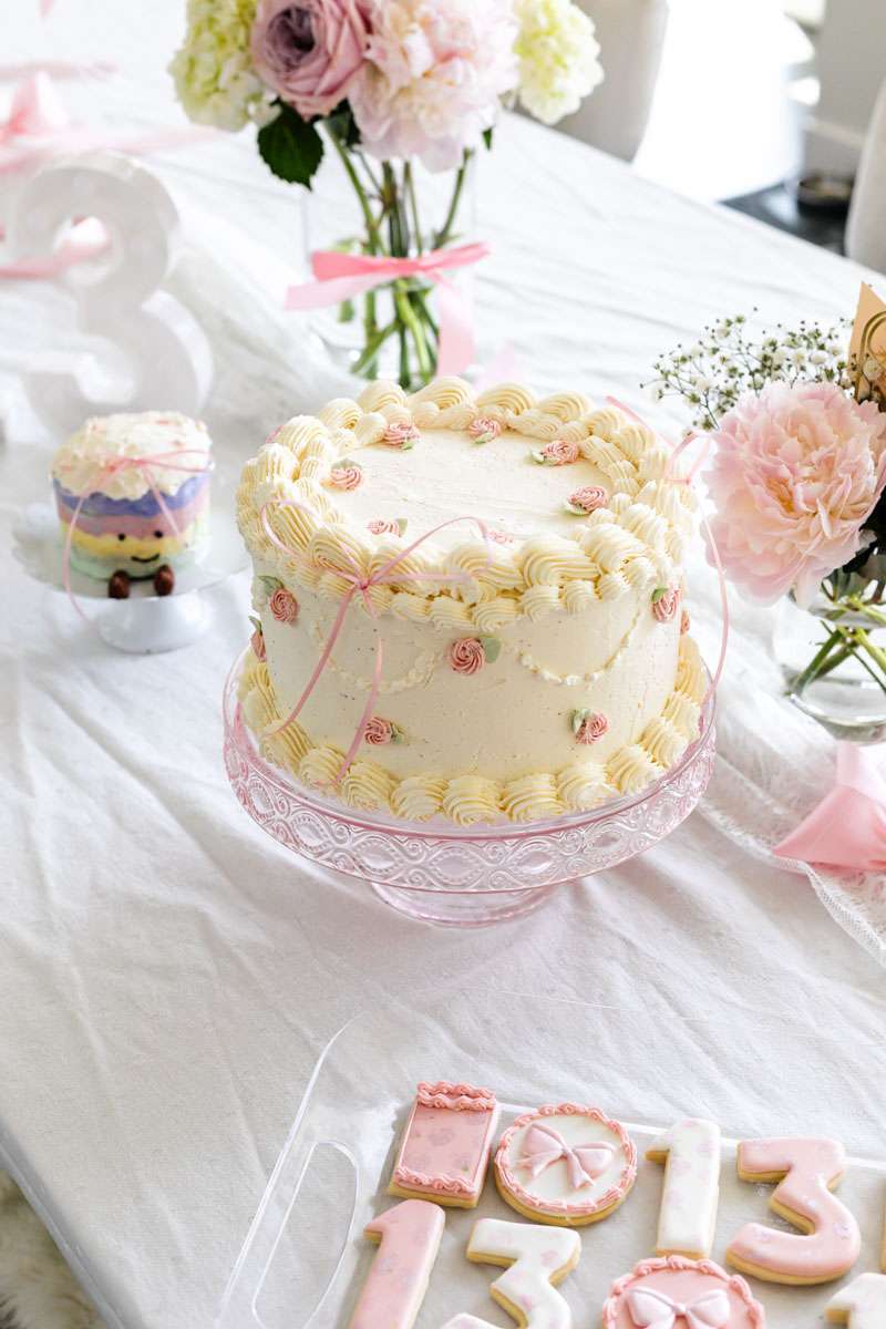 Homemade vintage inspired birthday cake with rosettes and scalloped lambeth piped details.