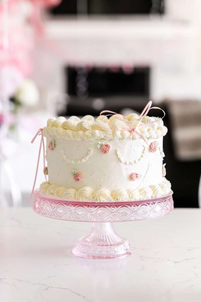 Homemade vintage inspired birthday cake with rosettes and scalloped lambeth piped details.