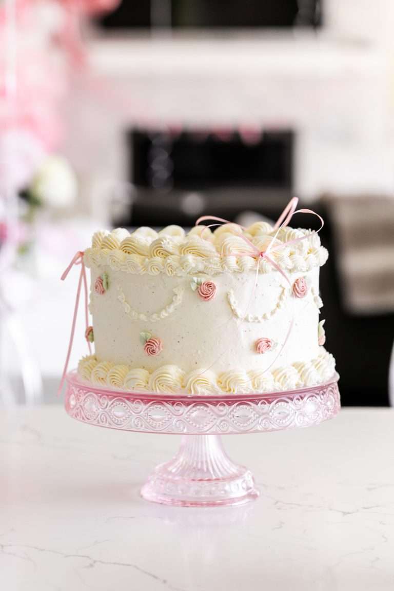 Homemade vintage inspired birthday cake with rosettes and scalloped lambeth piped details.